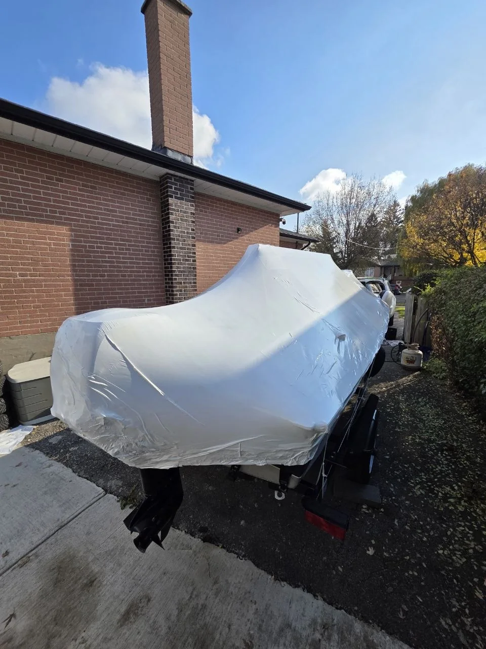 Boat and motor protected with white shrink wrap