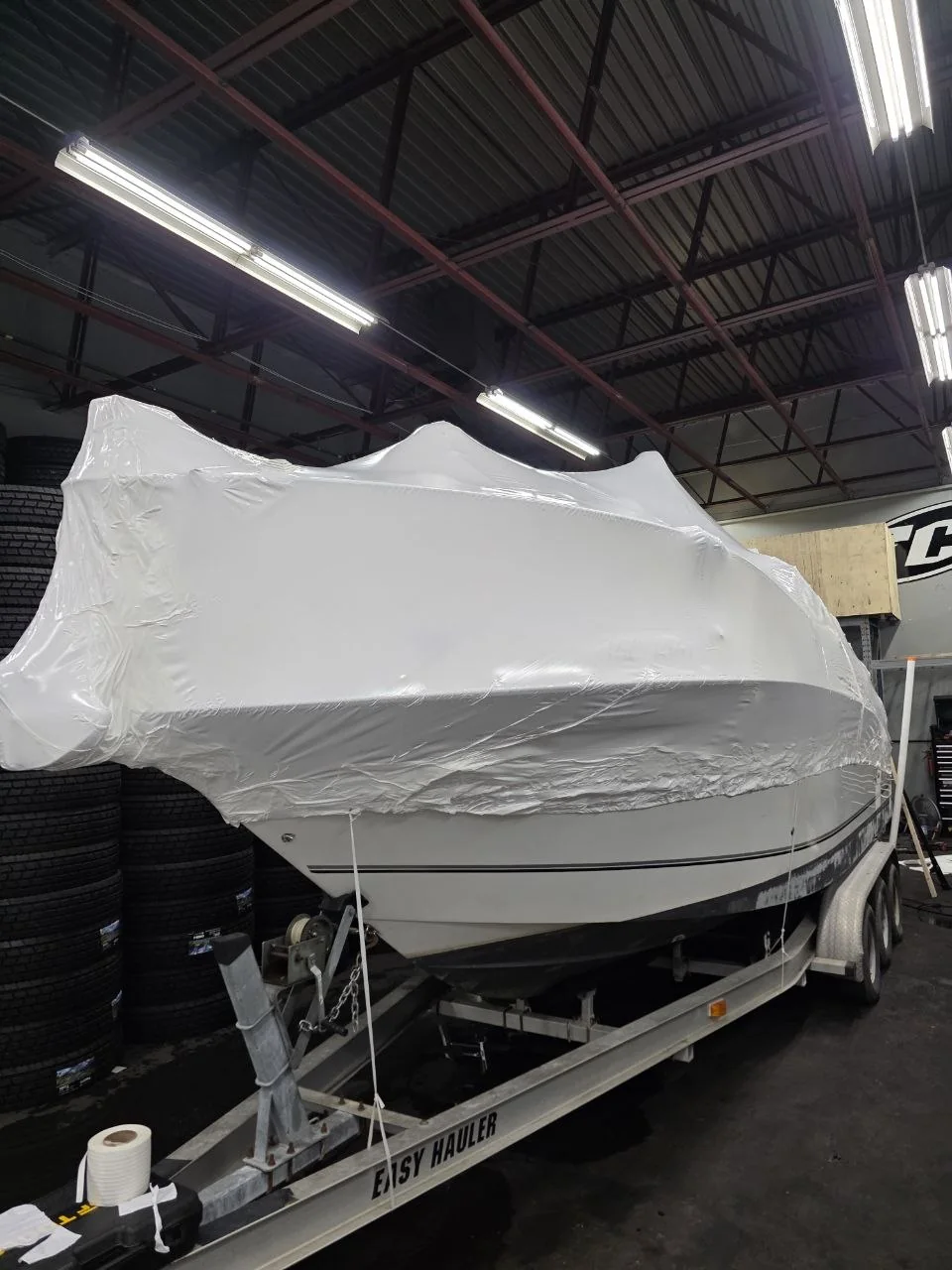 Boat protected with fitted white shrink wrap from the side