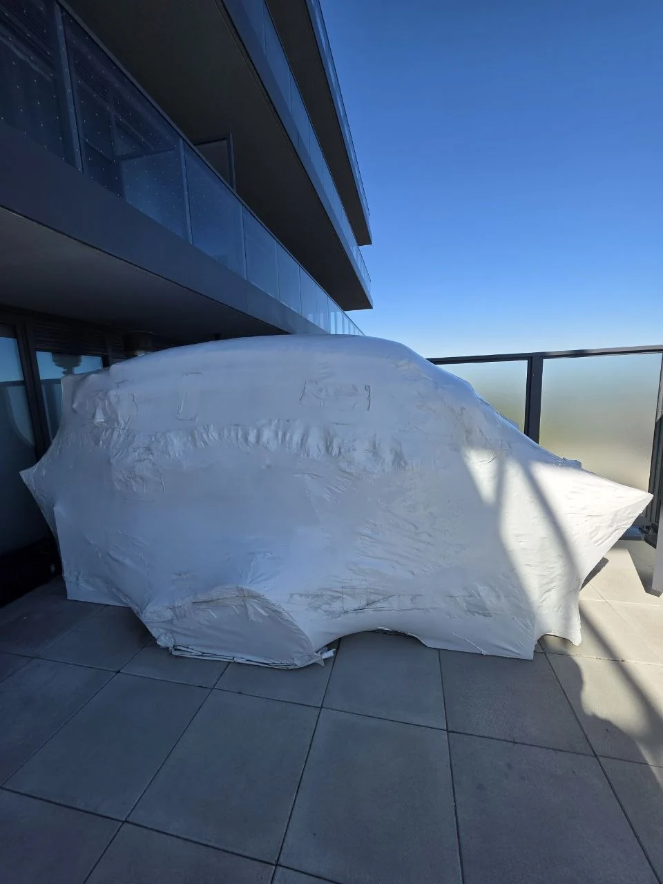 Balcony furniture protected with fitted white shrink wrap