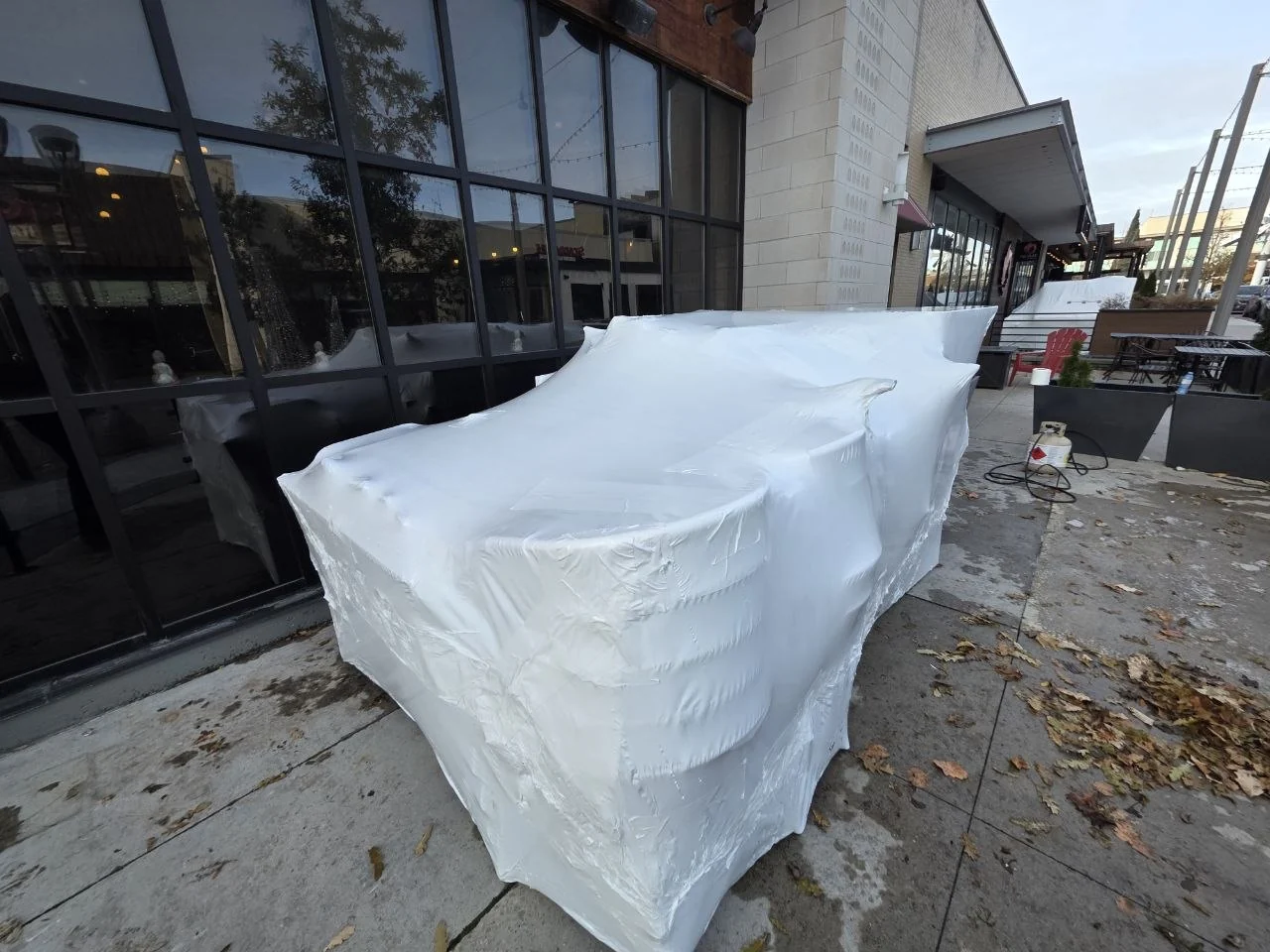 Large commercial furniture grouping protected beside a restaurant