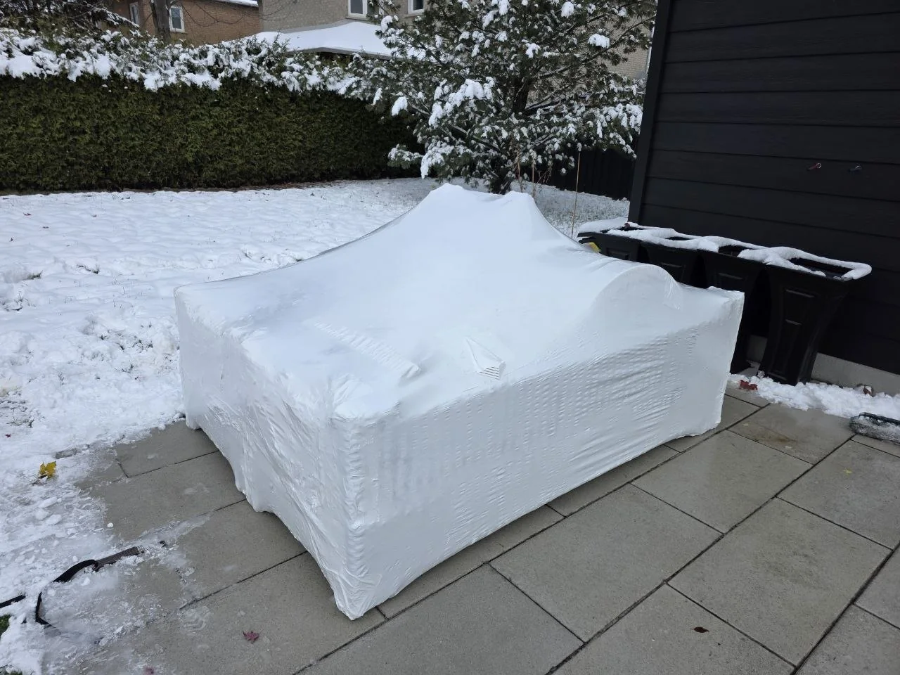 Residential patio furniture grouped under fitted white shrink wrap